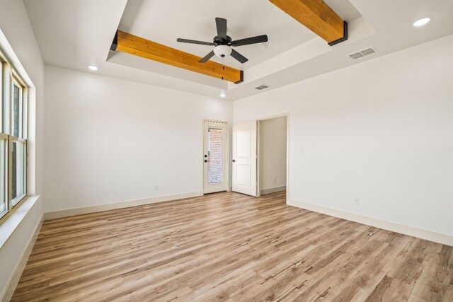 unfurnished room with a tray ceiling, light hardwood / wood-style floors, and ceiling fan