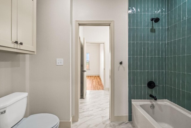 bathroom with tiled shower / bath and toilet