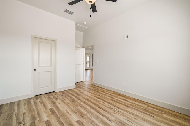 empty room with ceiling fan and light hardwood / wood-style flooring