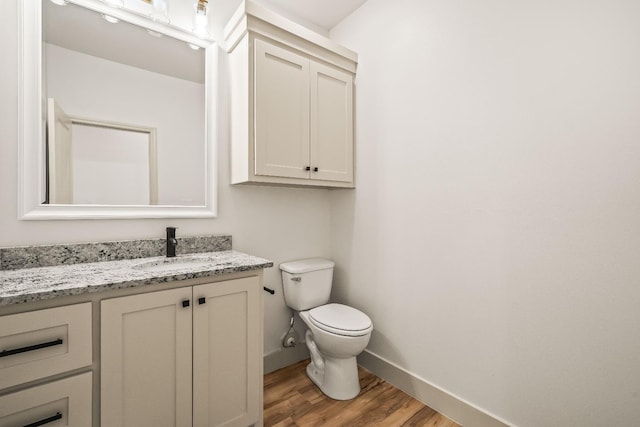 bathroom featuring vanity, toilet, and hardwood / wood-style floors