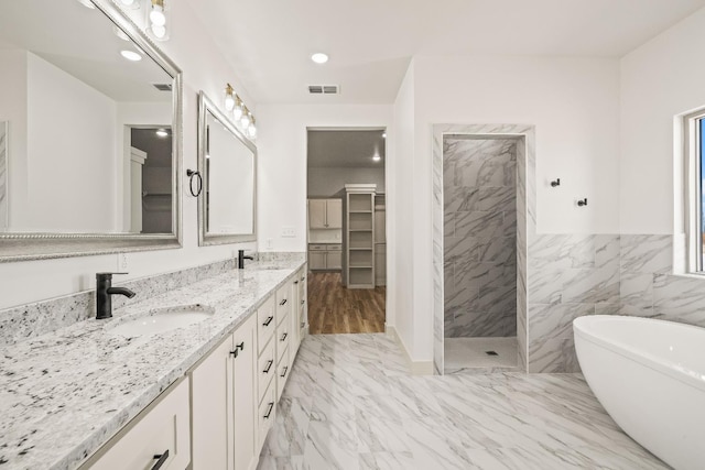 bathroom with plus walk in shower, tile walls, and vanity