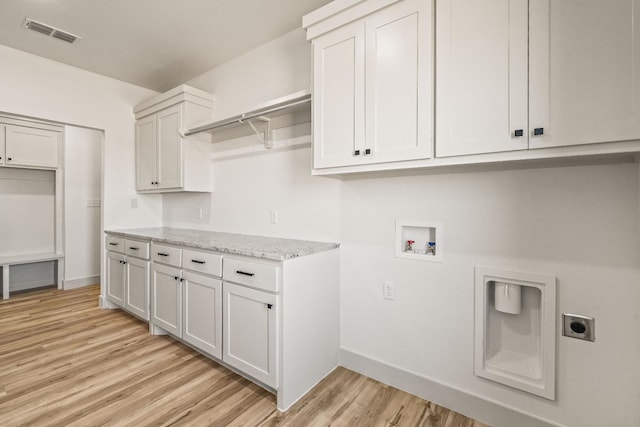 laundry room with hookup for a washing machine, light hardwood / wood-style flooring, cabinets, and hookup for an electric dryer