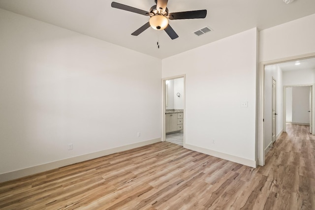 unfurnished bedroom featuring ceiling fan, ensuite bathroom, and light hardwood / wood-style floors