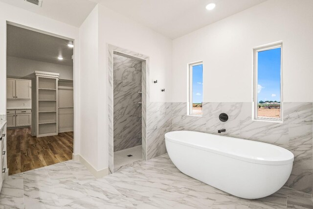 bathroom with vanity and shower with separate bathtub