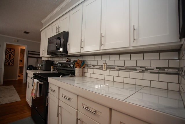 kitchen with crown molding, dark wood-type flooring, tasteful backsplash, black appliances, and white cabinets