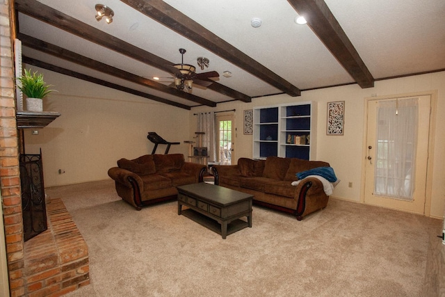 living room with beamed ceiling, a brick fireplace, light carpet, and ceiling fan