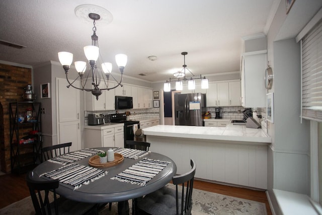 dining room featuring crown molding, an inviting chandelier, sink, and hardwood / wood-style floors