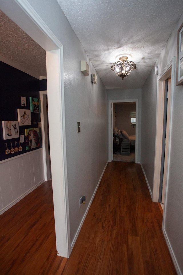 hallway featuring dark hardwood / wood-style flooring and a textured ceiling