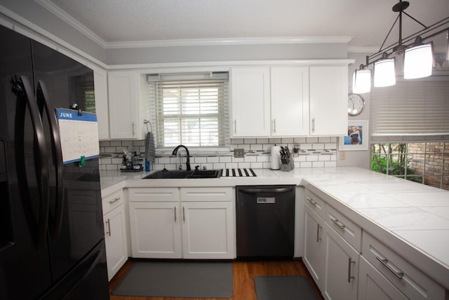 kitchen with decorative light fixtures, white cabinetry, sink, and black appliances