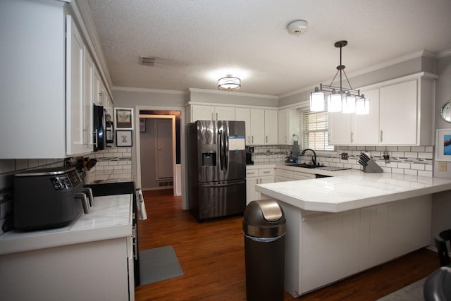 kitchen with white cabinetry, decorative light fixtures, stainless steel fridge, and kitchen peninsula