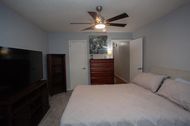 bedroom with ceiling fan, carpet flooring, and a textured ceiling