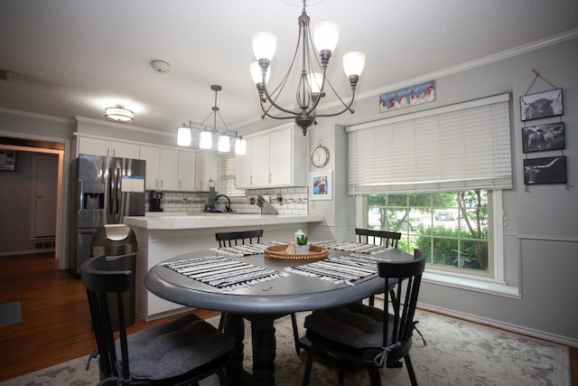 dining room with hardwood / wood-style floors, crown molding, a chandelier, and a textured ceiling