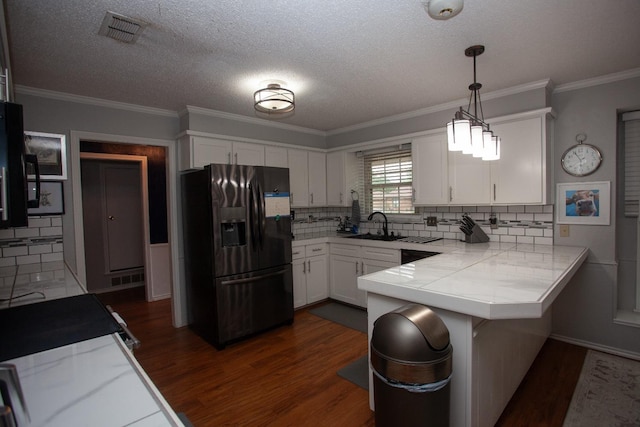 kitchen featuring pendant lighting, stainless steel fridge, dark hardwood / wood-style floors, white cabinets, and kitchen peninsula