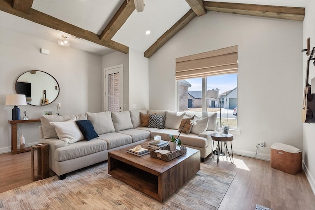 living room featuring baseboards, vaulted ceiling with beams, and light wood-style floors