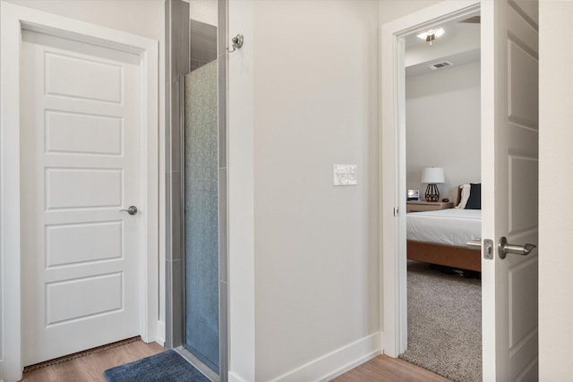 full bathroom with wood finished floors, visible vents, an enclosed shower, and ensuite bathroom