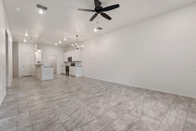 unfurnished living room featuring ceiling fan with notable chandelier