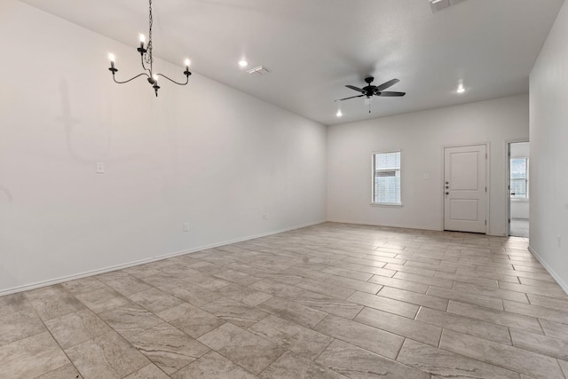 unfurnished room featuring ceiling fan with notable chandelier