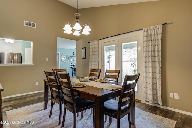 8609 Kenosha Dr, Lubbock, TX 79423 - dining area with dark wood-style floors, a chandelier, a high ceiling, and baseboards