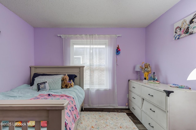 8609 Kenosha Dr, Lubbock, TX 79423 - bedroom with dark wood-style flooring, a textured ceiling, and baseboards