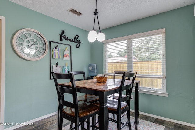 8609 Kenosha Dr, Lubbock, TX 79423 - dining room with a textured ceiling, dark wood-type flooring, and baseboards