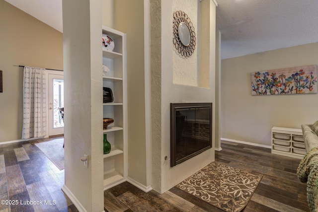 8609 Kenosha Dr, Lubbock, TX 79423 - living area with dark wood-style flooring, baseboards, a glass covered fireplace, and built in features