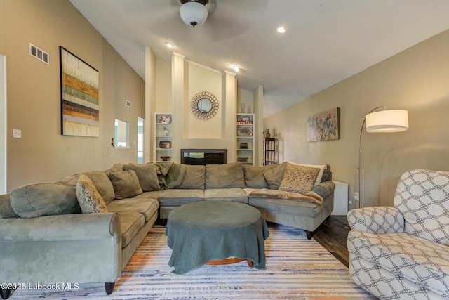 8609 Kenosha Dr, Lubbock, TX 79423 - living area with vaulted ceiling, a fireplace, wood finished floors, built in features, and recessed lighting