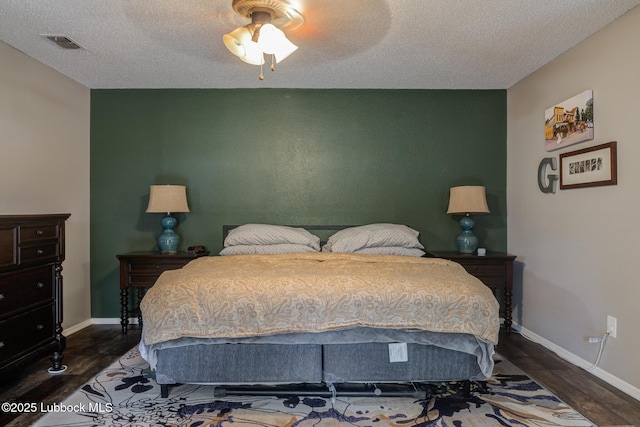8609 Kenosha Dr, Lubbock, TX 79423 - bedroom featuring wood finished floors, baseboards, a textured ceiling, ceiling fan, and an accent wall