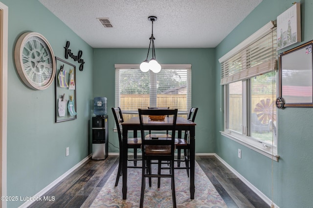 8609 Kenosha Dr, Lubbock, TX 79423 - dining room featuring dark wood-style flooring, a textured ceiling, and baseboards