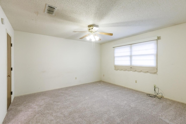 unfurnished room featuring light carpet, ceiling fan, and a textured ceiling