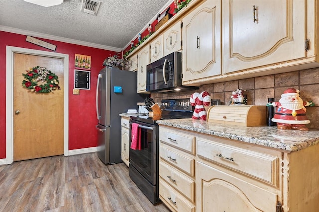 kitchen with appliances with stainless steel finishes, light wood-type flooring, backsplash, crown molding, and a textured ceiling