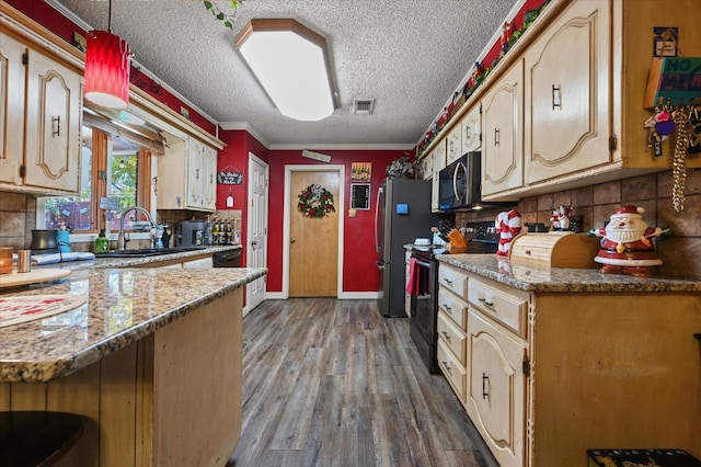 kitchen with wood-type flooring, backsplash, light stone counters, black appliances, and crown molding