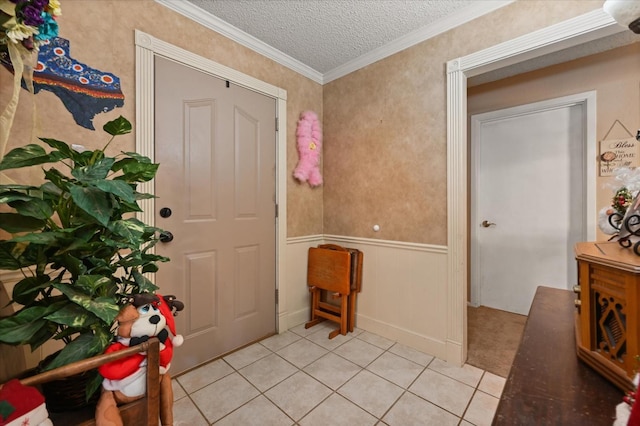 tiled entryway featuring crown molding and a textured ceiling