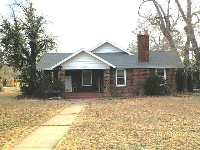 view of front of house with a porch and a front lawn