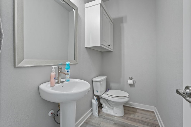 bathroom with wood-type flooring and toilet