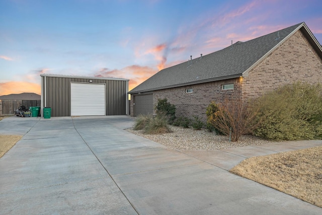 property exterior at dusk with a garage and an outdoor structure