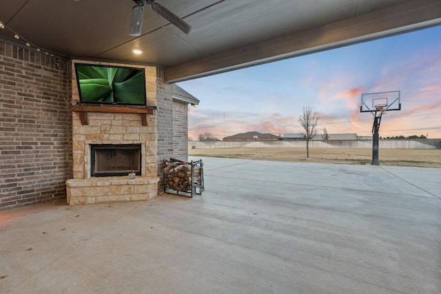 view of patio with ceiling fan and an outdoor stone fireplace