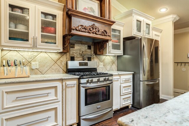 kitchen with light stone countertops, backsplash, ornamental molding, and stainless steel appliances