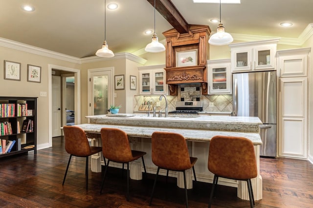 kitchen featuring a kitchen island with sink, decorative light fixtures, and stainless steel appliances