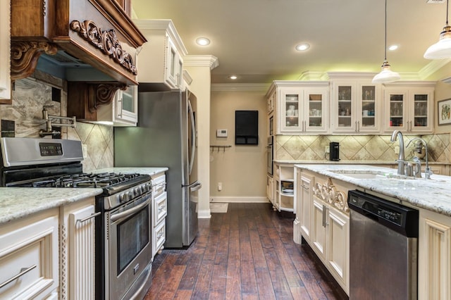 kitchen with pendant lighting, sink, crown molding, and stainless steel appliances