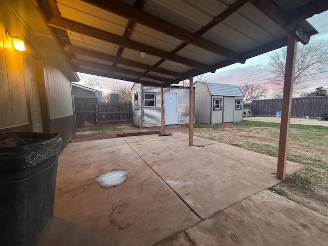 patio terrace at dusk featuring a storage shed