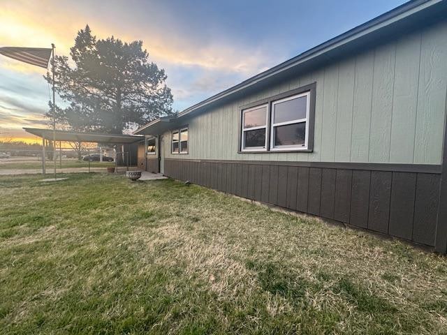 property exterior at dusk featuring a yard