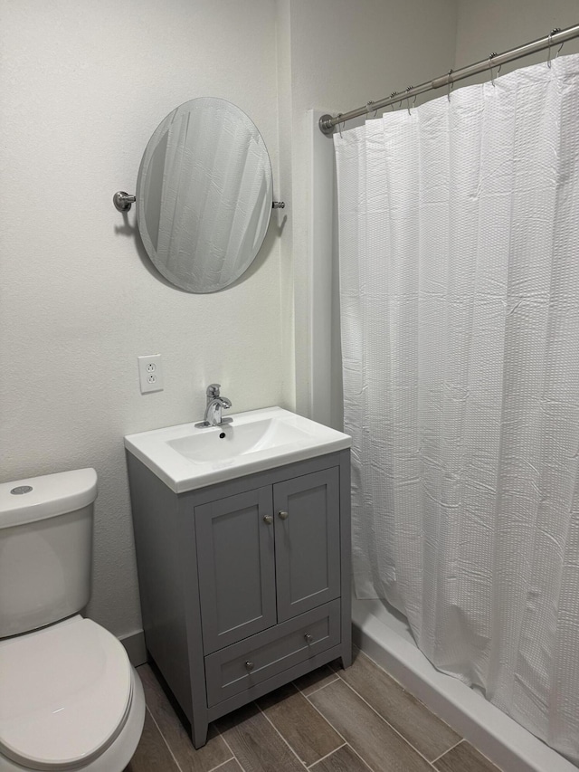 bathroom with vanity, curtained shower, and toilet