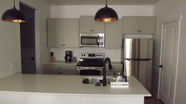 kitchen featuring gray cabinets, appliances with stainless steel finishes, sink, and decorative light fixtures