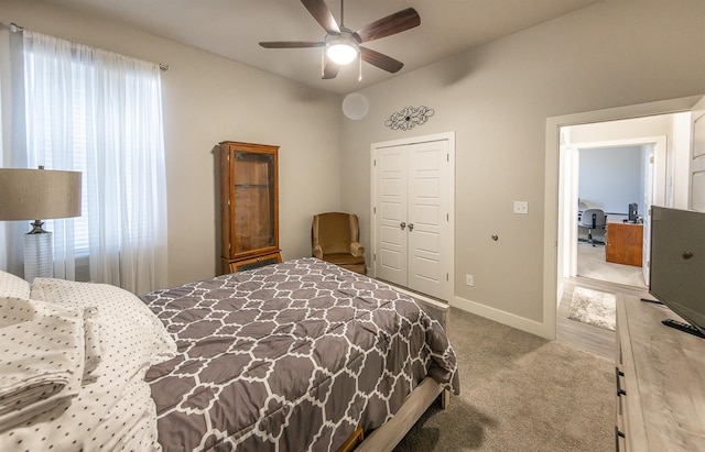 carpeted bedroom featuring ceiling fan and a closet