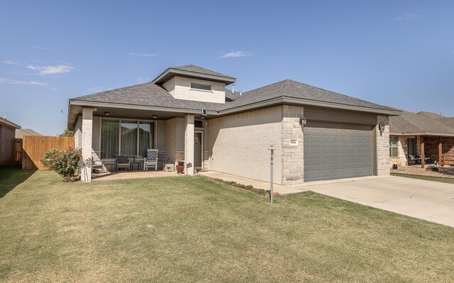 prairie-style house featuring a garage, a patio area, and a front lawn