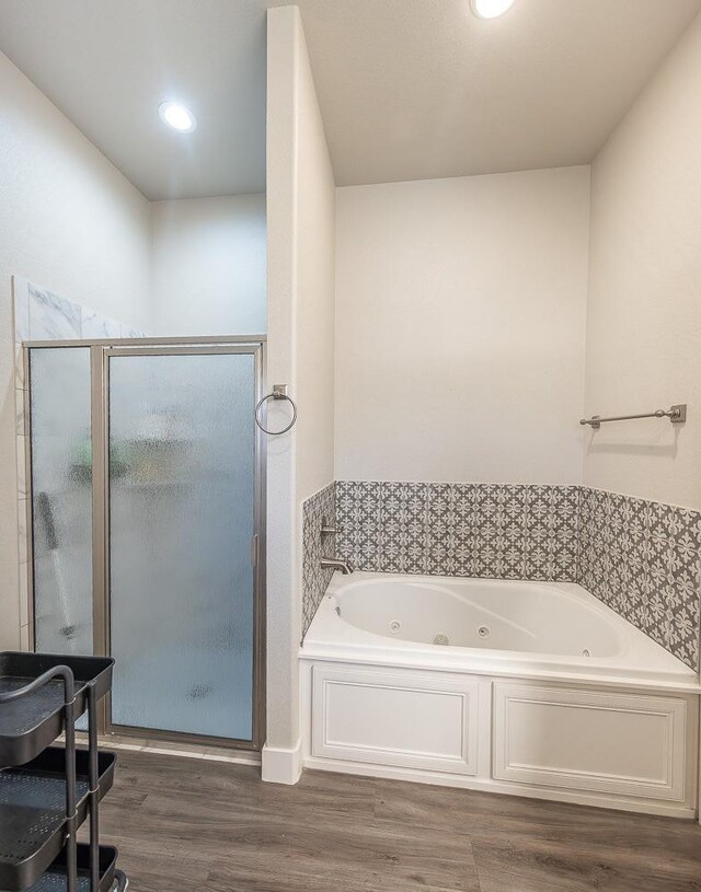 bathroom with shower with separate bathtub and hardwood / wood-style floors