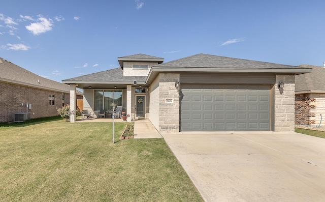 prairie-style home with central AC unit, a garage, and a front yard