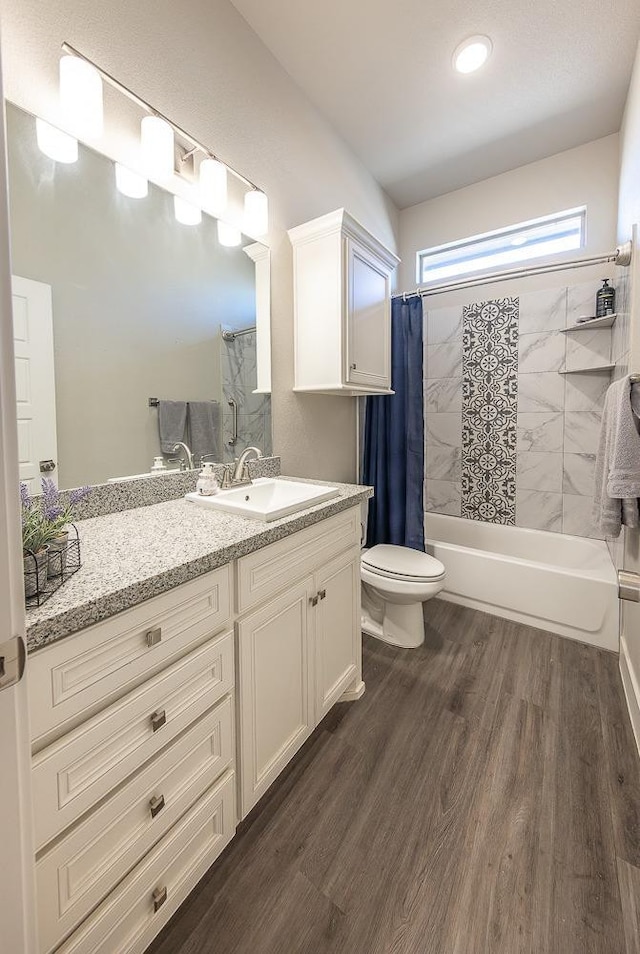 full bathroom featuring hardwood / wood-style flooring, vanity, toilet, and shower / bath combo with shower curtain