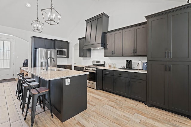 3615 121st St, Lubbock, TX 79423 - kitchen with stainless steel appliances, arched walkways, decorative backsplash, an island with sink, and hanging light fixtures