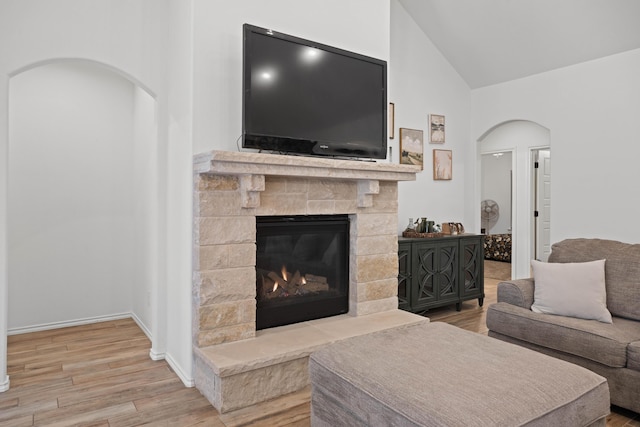 3615 121st St, Lubbock, TX 79423 - living room with wood finished floors, high vaulted ceiling, arched walkways, and a stone fireplace